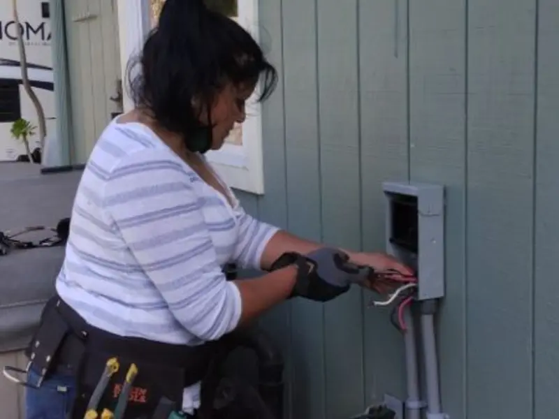 Licensed electrician wiring an exterior subpanel in Salina